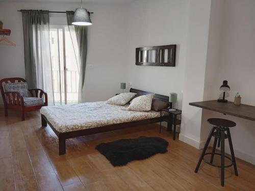 萨贡托Ideal Apartamento para familia con wifi的卧室配有1张床、1张桌子和1把椅子