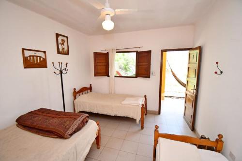 卡法亚特Hostel Lo de Chichi的一间卧室配有两张床和吊扇