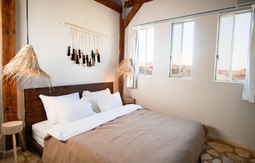 祖奇姆Selina Tzukim - Soft opening - סלינה צוקים的一间卧室配有一张带白色床单和窗户的床。
