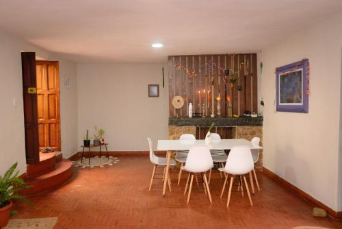 Los Baños del IncaKinti Wasi Casa de Campo的一间带桌子和白色椅子的用餐室