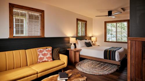 盖尔南维尔Highlands Resort - Adults Only的一间卧室配有一张床、一张沙发和窗户。