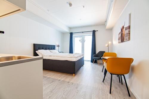 斯沃尔韦尔Stylish and serviced Studio apartment in Lofoten的卧室配有一张床和一张桌子及椅子