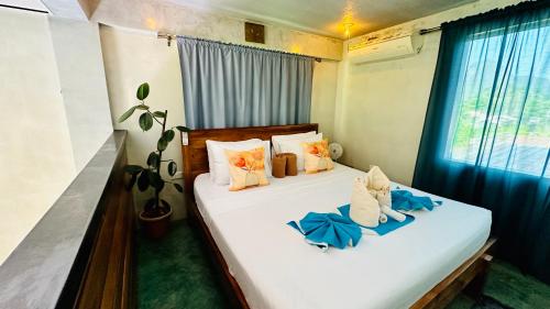 爱妮岛Hidden of Cailan Inn的一间卧室设有两张带蓝色床单的床和窗户。