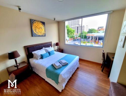 科恰班巴Margarita Apartamentos的一间卧室设有一张床和一个大窗户
