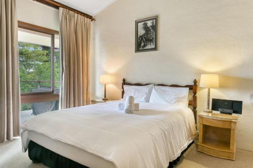 温特沃斯瀑布独景公寓的卧室设有一张白色大床和一扇窗户。