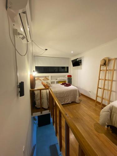 坦迪尔Belgrano 360的一间卧室配有一张床,铺有木地板