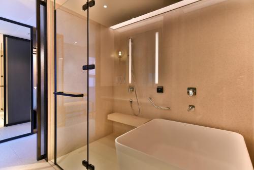 八里八里福朋喜来登酒店的带淋浴和白色浴缸的浴室