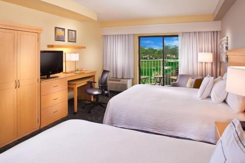 德斯坦盛大大道圣德斯廷万怡酒店的酒店客房设有两张床、一张桌子和一台电视。