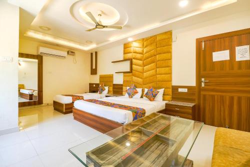 瓜廖尔FabHotel Royal Aanandam的酒店客房,设有两张床和一张玻璃桌