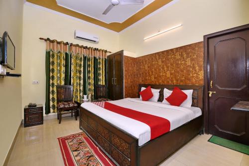 MājraMorning Star的一间卧室配有一张带红色枕头的大床