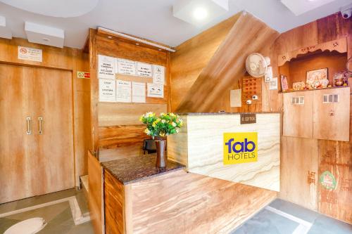 瓜廖尔FabExpress Ambika Dx的一间设有木墙的房间和一个花卉柜台