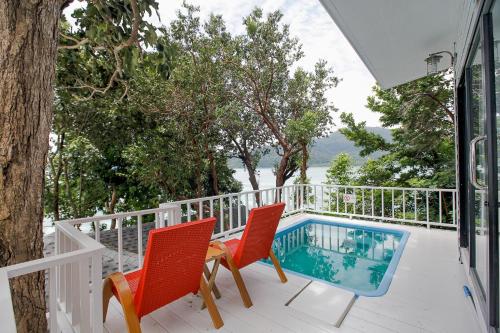 丽贝岛Casa De Lipe的一个带两把椅子的阳台和一个游泳池