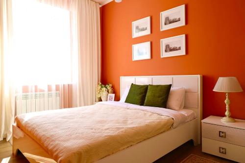 KaynazarkaBerry House close to Talgar Almaty的一间卧室拥有橙色的墙壁,配有一张带绿色枕头的床。