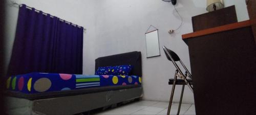 茂物FAI Bogor Backpacker by SPAZIE的一间卧室配有床和蓝色窗帘