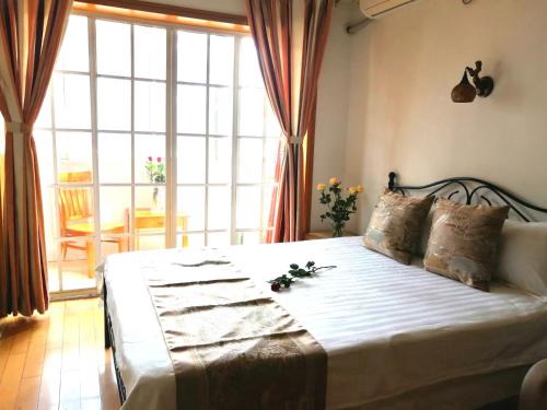 上海Lily's home的一间卧室配有一张带鲜花的大床