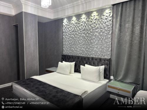 巴库琥珀酒店的一间卧室配有带白色床单和枕头的床。