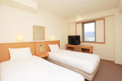 奈良奈良微笑酒店的酒店客房设有两张床和电视。