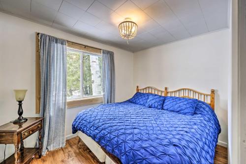 MadawaskaCozy Maine Lakefront Cabin Rental的一间卧室配有一张带蓝色棉被的床和窗户。