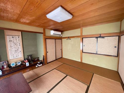 鹤冈市大聖坊 Daishobo的空房间设有2扇窗户和木制天花板