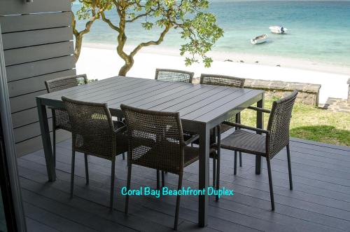 蓝海湾Coral Bay by Dream Escapes的海滩甲板上的桌椅