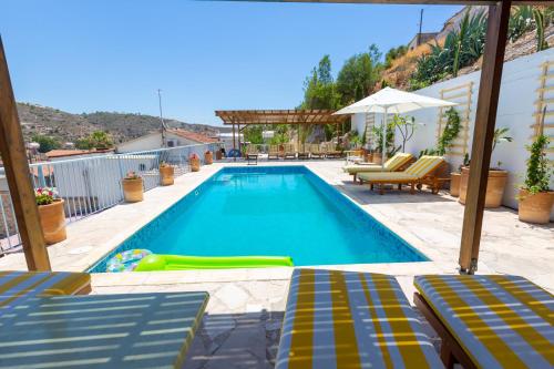卡拉瓦索斯Cyprus Villages Kalavasos的一个带躺椅和遮阳伞的游泳池