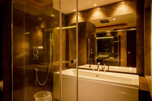 RourkelaHOTEL PAHADI的一间带玻璃淋浴和水槽的浴室