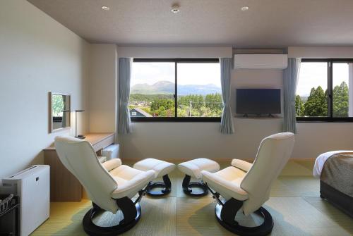 阿苏市Aso Hakuun Sanso的一间设有两把椅子和一张床及窗户的房间