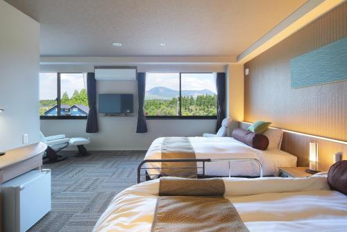 阿苏市Aso Hakuun Sanso的酒店客房设有两张床和大窗户。