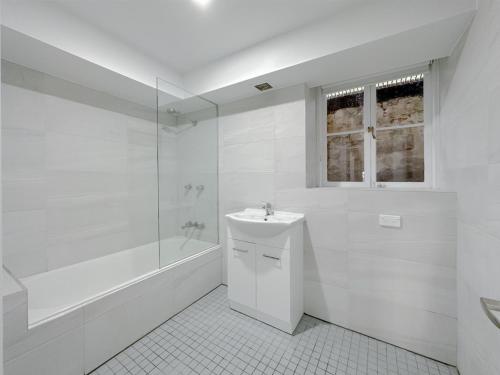 悉尼Kent Cosy House的白色的浴室设有水槽和浴缸。