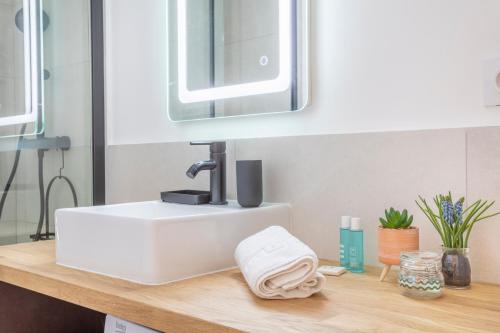 加尔达讷Garlaban - Linge de qualité - Fibre - Confort - Cœur de Ville的浴室设有白色水槽和镜子