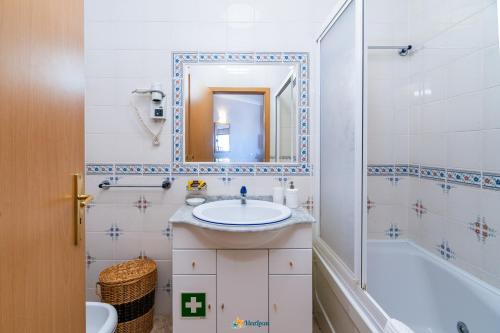波尔蒂芒Praia Mar - Apartamento Viva Local的一间带水槽、浴缸和镜子的浴室