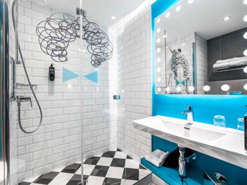 什切青ibis Styles Szczecin Stare Miasto的浴室铺有蓝色和白色瓷砖,配有水槽