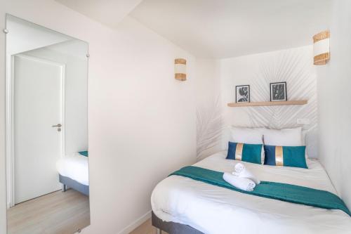 加尔达讷Garlaban - Linge de qualité - Fibre - Confort - Cœur de Ville的一间卧室配有一张带蓝色和白色枕头的床