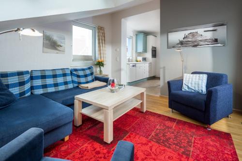 诺德奈Inseldomizil Whg 03的客厅配有蓝色的沙发和桌子