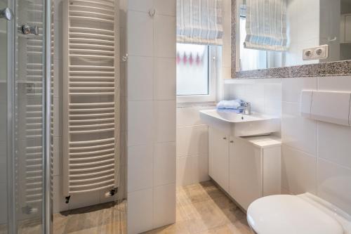 诺德奈Inseldomizil Whg 03的白色的浴室设有卫生间和水槽。
