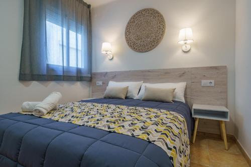 布拉内斯AR Apartaments Camps的一间卧室设有蓝色的床和窗户。