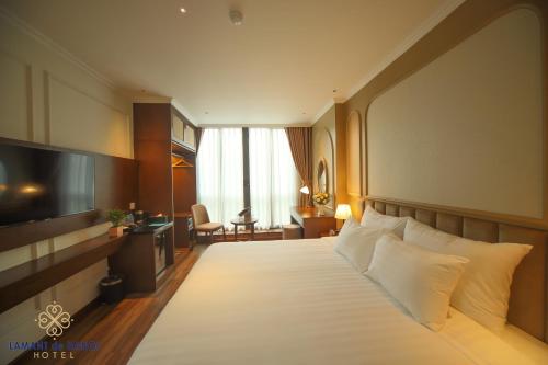 河内L'amant de Hanoi Hotel - khách sạn Lamant de Hà Nội的酒店客房,配有床和电视