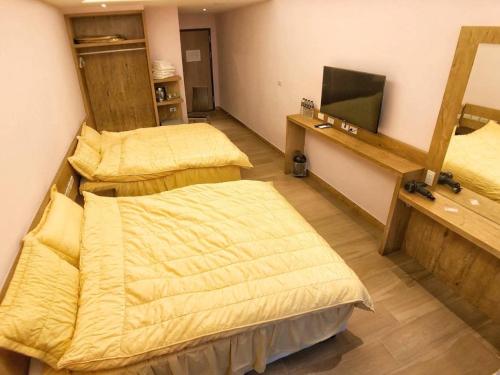 马公顺成休闲会馆的一间设有两张床和镜子的房间