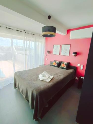 阿格德角Cap d'Agde Naturiste F的一间卧室配有一张带粉红色墙壁的大床