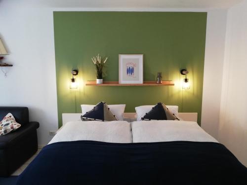 费马恩Kajüthus Apartment 5的一间卧室设有一张床和绿色的墙壁