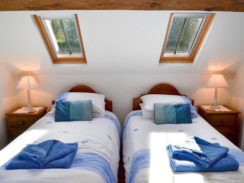 HawardenWoodhouse Cottage的带2扇窗户的小客房内的2张床