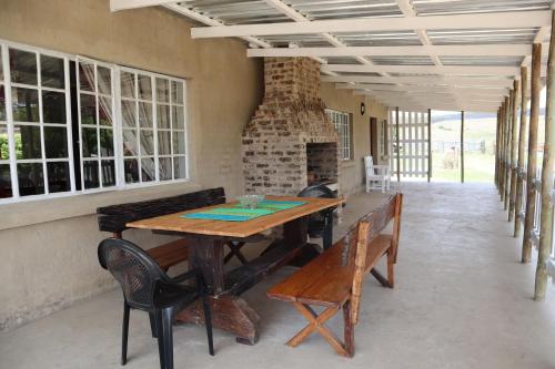 LochielRocks & Roses Farm stay的一间带木桌和长凳的用餐室