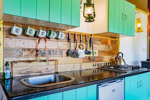 SwanepoelskraalAfriCamps Addo的厨房配有绿色橱柜和水槽