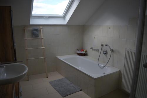 Ferienwohnung Rißblick的带浴缸、水槽和窗户的浴室