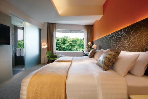 新加坡D'Hotel Singapore managed by The Ascott Limited的一间卧室配有一张带橙色墙壁的大床