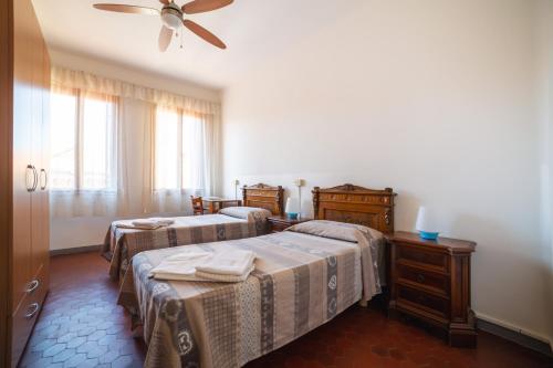 威尼斯多莫斯西维卡旅馆的一间卧室配有两张床和吊扇