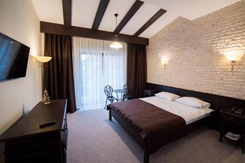 古拉哈莫卢洛伊Piatra Pinului Ski & Spa的配有一张床和一台平面电视的酒店客房