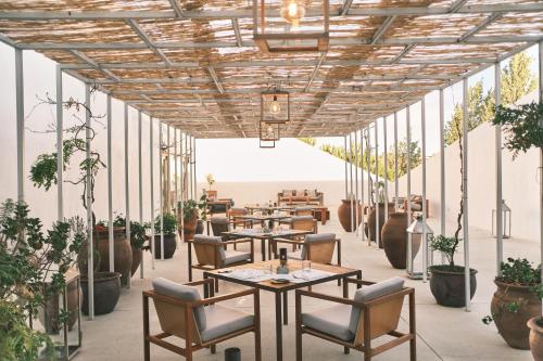 新蒙特莫尔兰德葡萄园酒店的一间设有桌椅和盆栽的餐厅