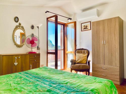 阿尔盖罗Casa Provence Family & Friends Mare & Natura的一间卧室配有一张床、一把椅子和镜子