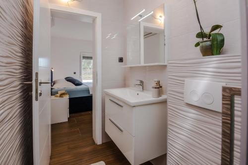 维尔Villa Tomic的白色的浴室设有水槽和镜子